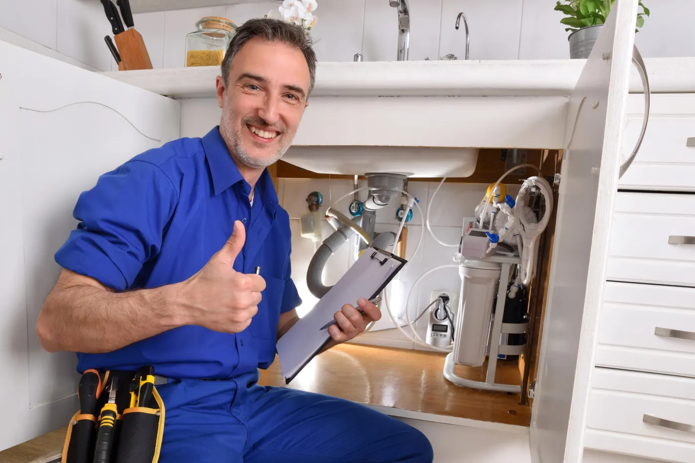 Artisan plombier de la maison Jobin & Yvon contrôlant une installation sous évier